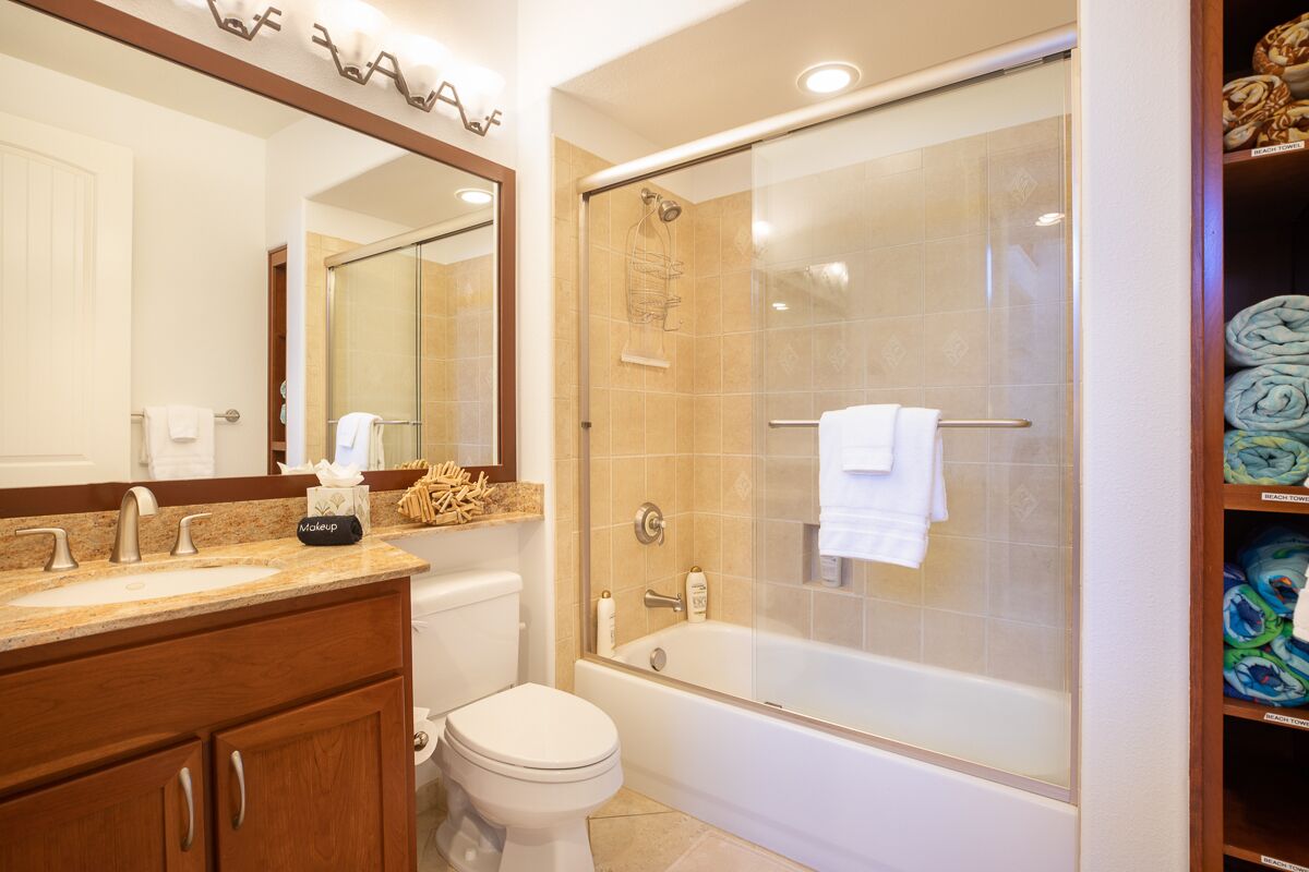Un bagno con doppio lavandino, toilette e cabina doccia in vetro.