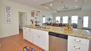 A spacious kitchen with granite countertops, white cabinetry, and a dishwasher. - Just steps to the Sand & Surf!  Sleeps 12, with 2 Master Suites! Perfect Rental! (Bolivar Peninsula)