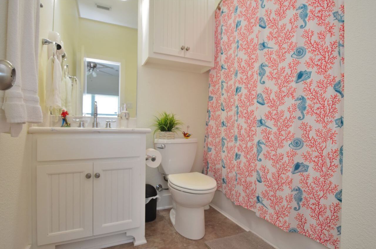 A bathroom with a toilet, sink, and cabinet.