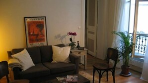Un salon avec un canapé, une table basse et une plante en pot.