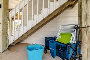 Stairs lead to an upper level, with a utility cart and bucket at the base.