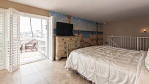 A bedroom with a bed, a dresser, a television, and a balcony with a view of the sea. - Paradise found in Oceanside with panoramic ocean view (Oceanside)