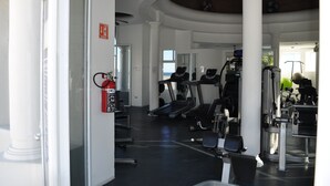 Uma academia com esteiras, elípticos e equipamentos de musculação.