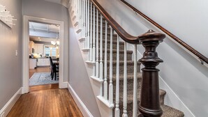 A staircase with wooden balusters and a dark handrail leading to a landing.