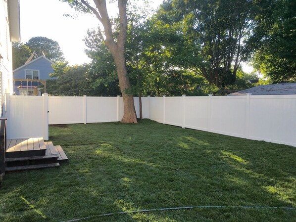 Enjoy a serene outdoor space with a well-manicured lawn and a deck area.