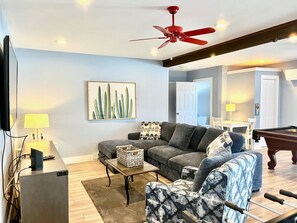 Relax in this stylish living room with a sofa, flat-screen TV, and pool table.