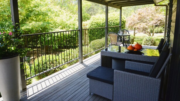 A covered outdoor patio with wicker furniture, a table, and a potted plant. - Farm Escape - Spacious Cottage in Kangaroo Valley (Kangaroo Valley)