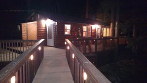 A wooden cabin with a porch and a covered walkway.