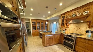 A spacious kitchen with wooden cabinets, stainless steel appliances, and a central island.