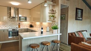 Una cocina moderna con una isla central, electrodomésticos de acero inoxidable y un revoque de ladrillo.