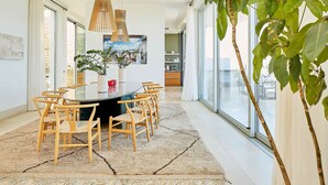Un comedor moderno con una mesa redonda, sillas de madera y un amplio ventanal con vistas a la ciudad.