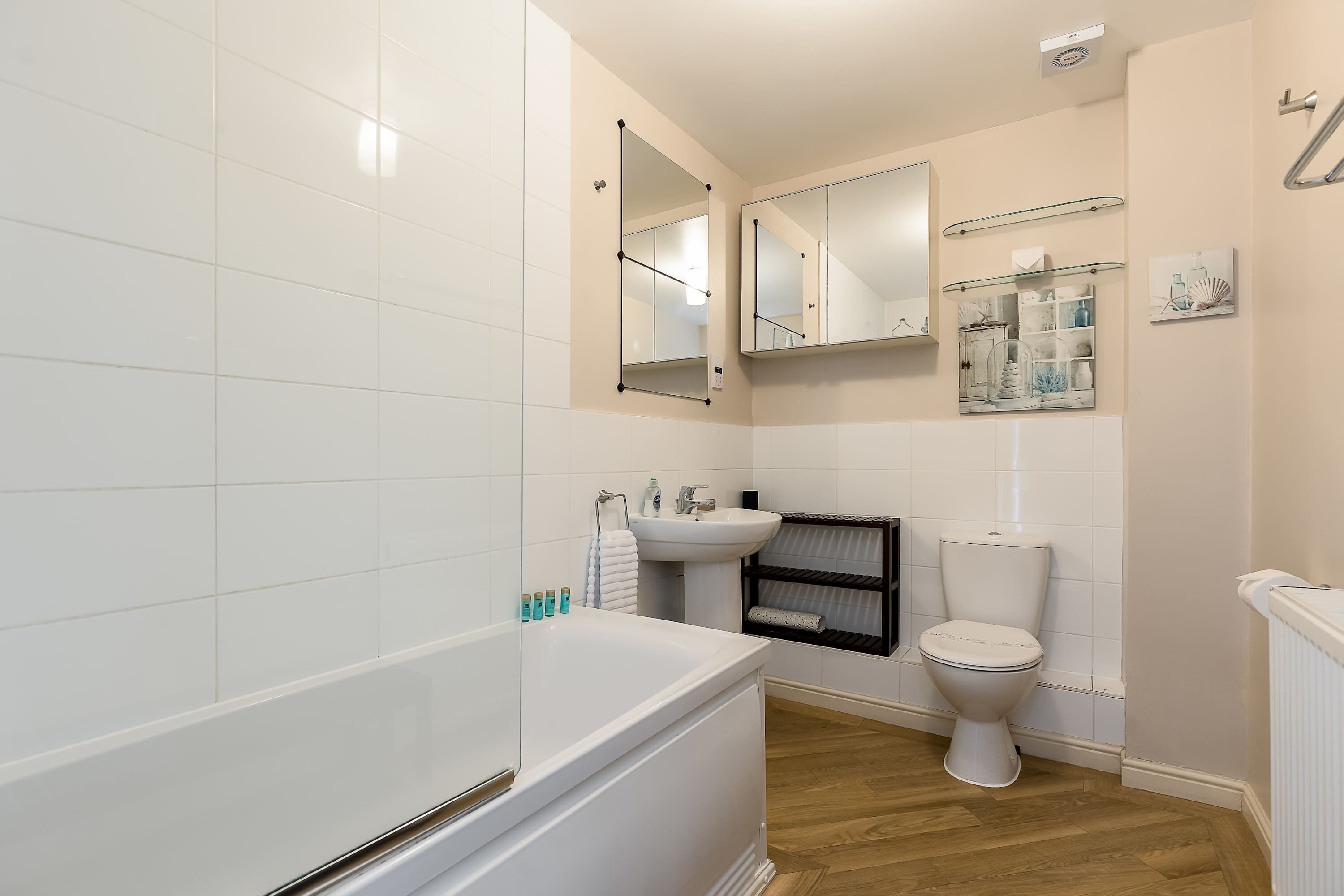 Uma casa de banho moderna com banheira, sanita e lavatório.