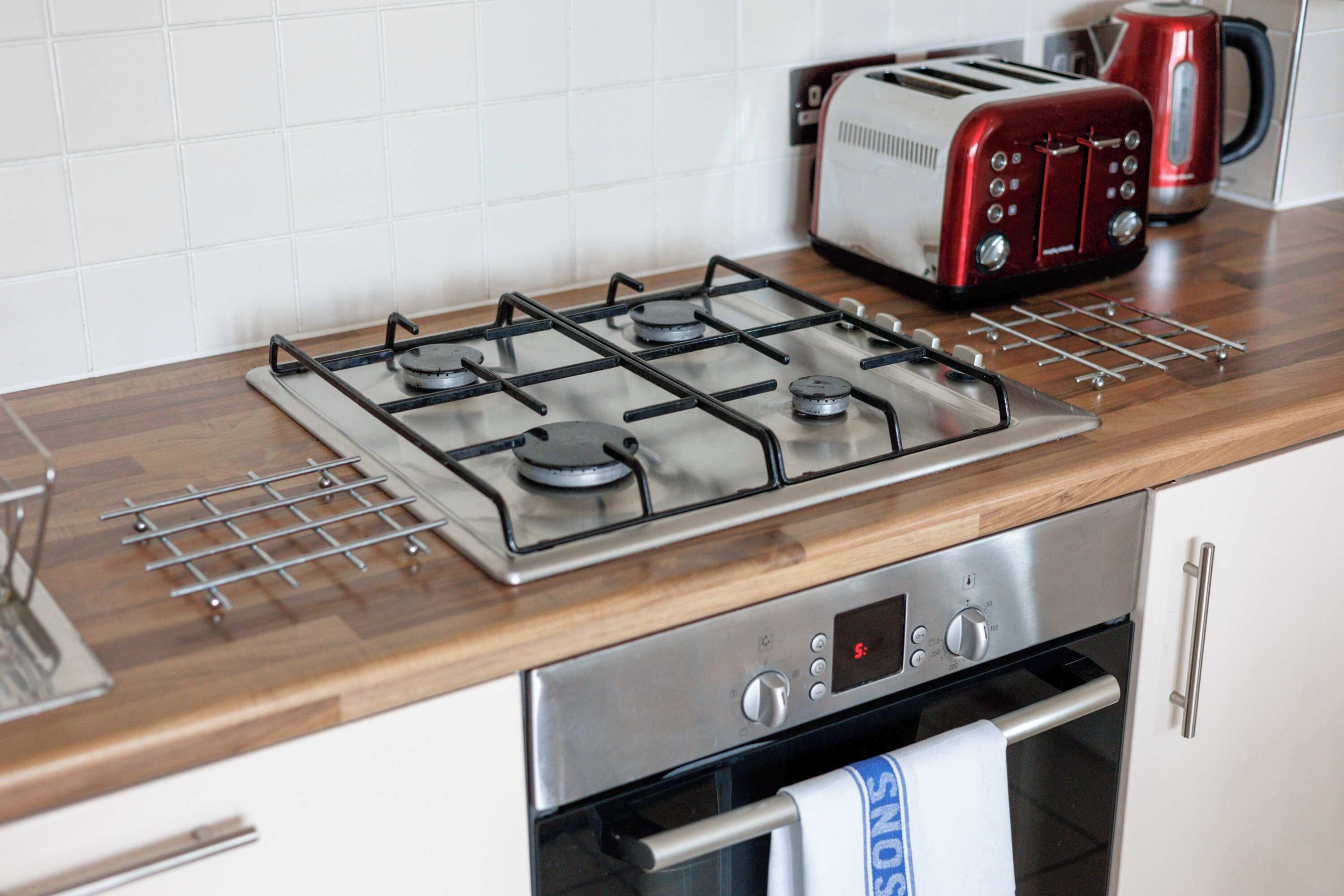 Une cuisine équipée d’une cuisinière à gaz, d’un grille-pain et d’un four.