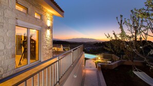 A stone building with a balcony overlooking a pool and mountains. - Spacious villa with full privacy & nature views! (Rethymno)