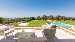 Ein Sitzbereich im Freien mit Pool und Blick auf die Landschaft.