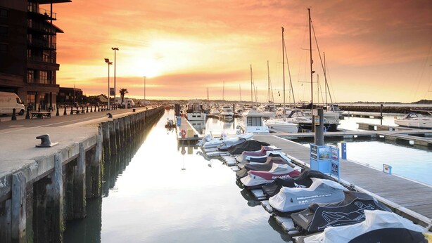 A marina with boats docked, a pier, and a building on the left. - Magnolia House - Townhouse in Old Town Poole (Poole)