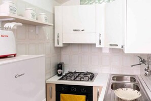 Refrigerador, horno, utensilios de cocina, mesa de comedor