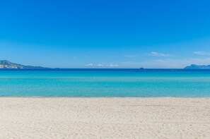 Una playa con aguas turquesas cristalinas y una orilla arenosa.