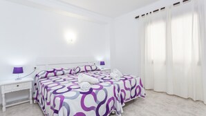 Une chambre à coucher avec un lit, des tables de chevet et une fenêtre avec des rideaux.