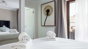 A hotel room with a bed, a large window, a door, and a wall-mounted artwork. - Sanderling - Close to Poole Quay and Baiter Park (Poole)