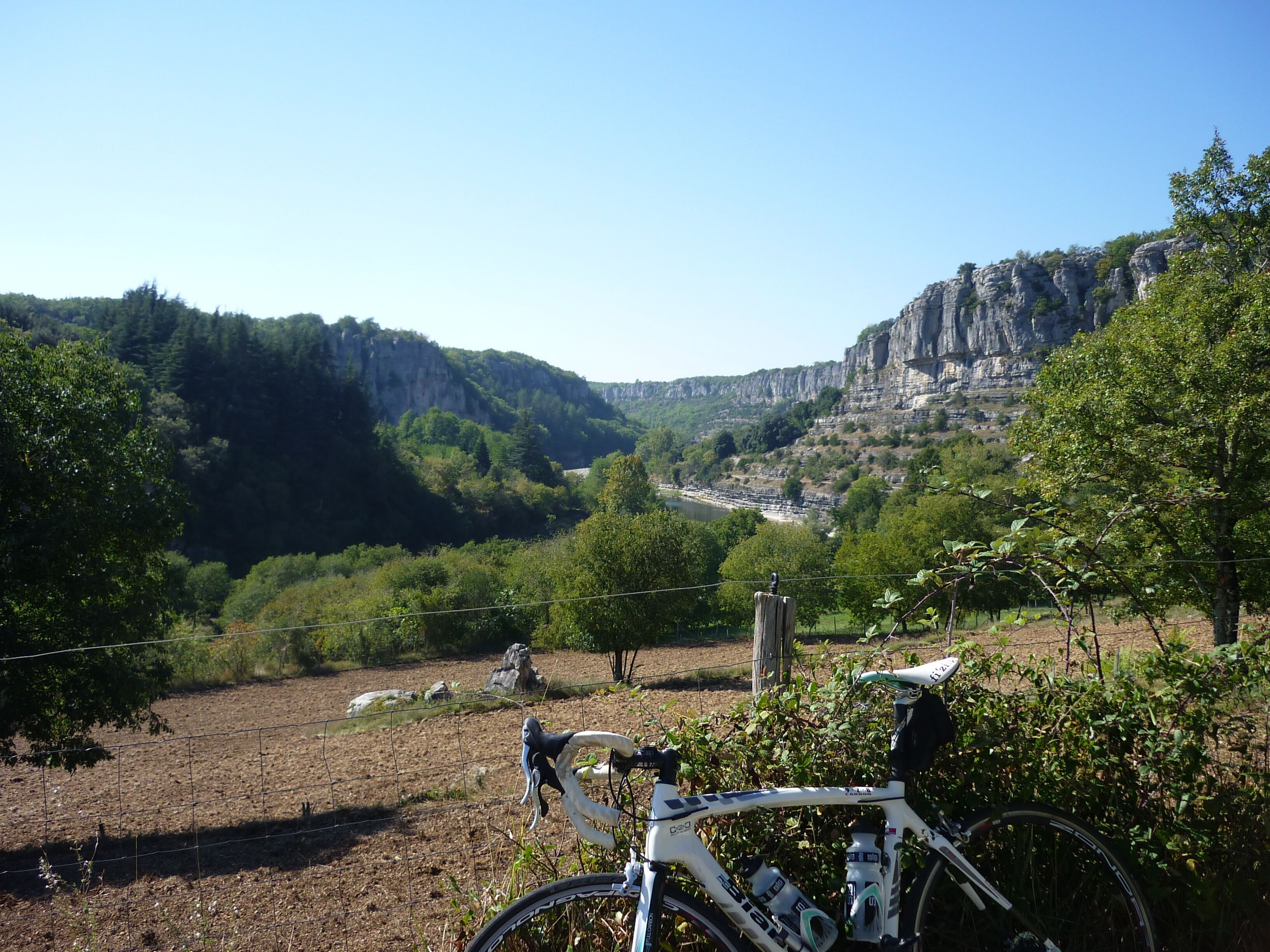 A bicycle parked in a rural setting with a mountainous backdrop.