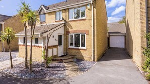 A two-story residential building with a garage, a front entrance, and a small garden area with palm trees. - Palma - Coastal Home near Harbour and beach (Poole)