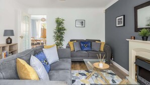 A modern living room with a grey sofa, a coffee table, and a fireplace. - Palma - Coastal Home near Harbour and beach (Poole)