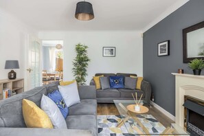 A modern living room with a grey sofa, a coffee table, and a fireplace. - Palma - Coastal Home near Harbour and beach (Poole)
