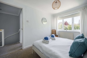 A bedroom with a bed, a chair, a window with a view, a mirror, and a door leading to another room. - Palma - Coastal Home near Harbour and beach (Poole)