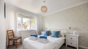 A bedroom with a bed, a chair, a nightstand, a lamp, and a window. - Palma - Coastal Home near Harbour and beach (Poole)