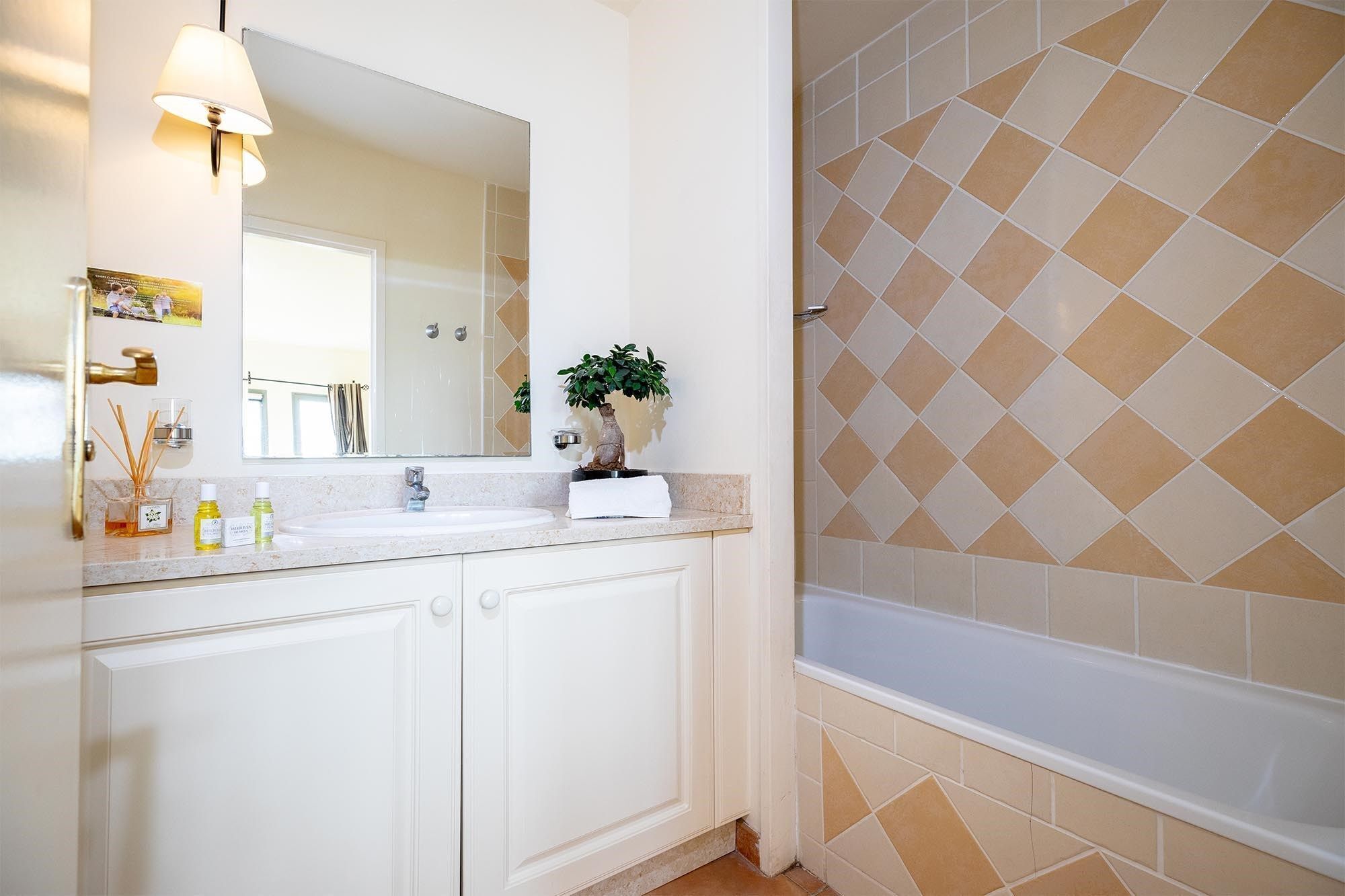Un baño con lavabo, espejo y zona de ducha.