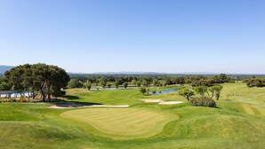 Ein Golfplatz mit Bunkern, Wasserhindernissen und einem Clubhaus.