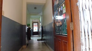A hallway with lockers on one side and a door at the end. - Hotel Dolphin (Kathmandu)