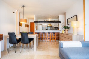A modern kitchen with a central island, bar stools, and a dining area with chairs. - Renovated 2026! Air-Conditioned Apartment with Seaview, shared pool and Wi-Fi in Port de Sóller (Port de Soller)