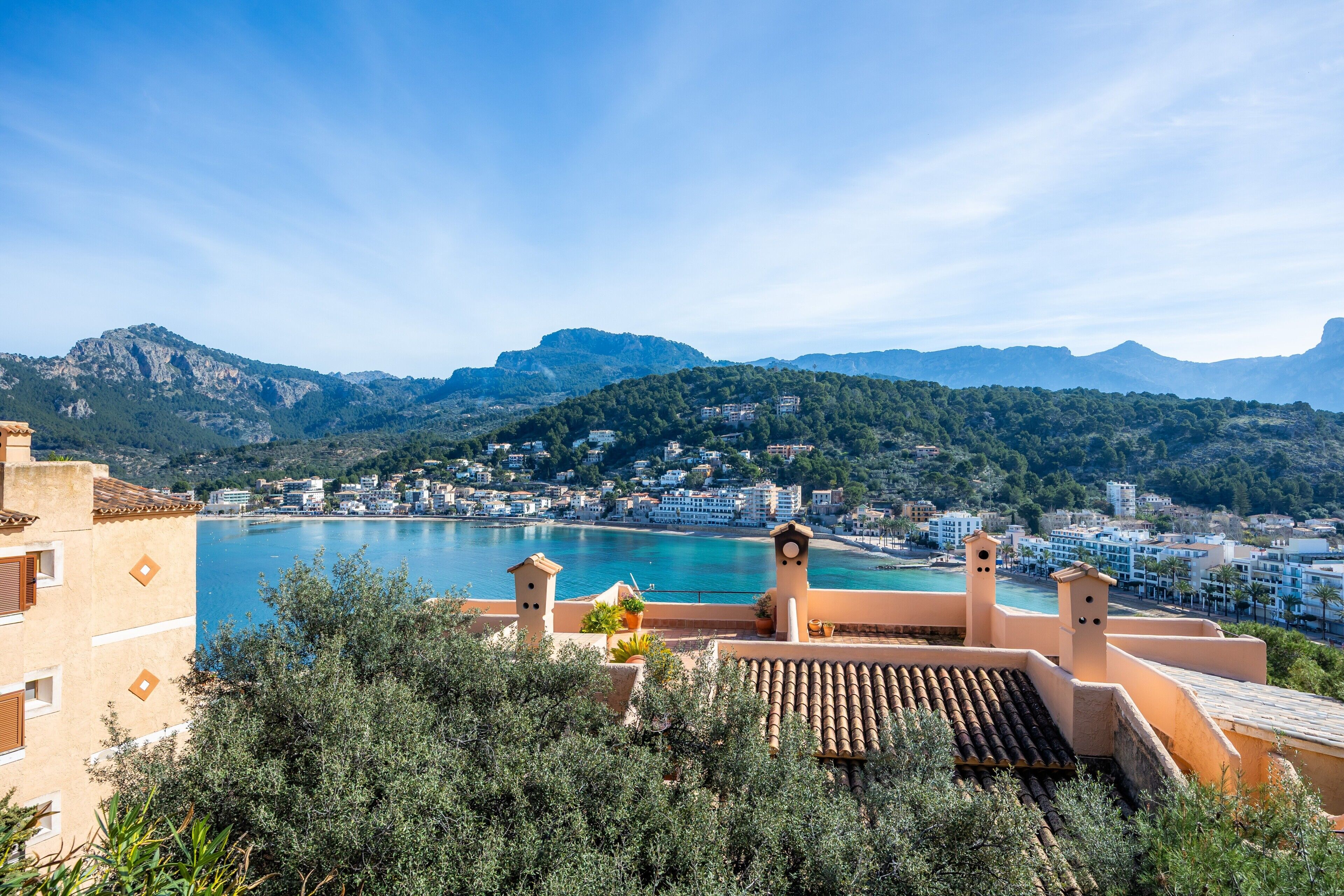 Un pueblo costero con vistas al mar, edificios y montañas.