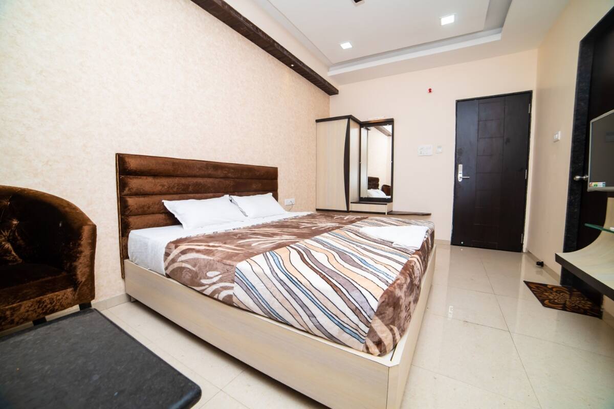 Une chambre à coucher avec un lit, une chaise, un miroir et une porte.