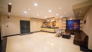 A spacious lobby with a reception desk, seating area, and a large wall-mounted artwork. - Hotel Indian Heritage (Raipur)