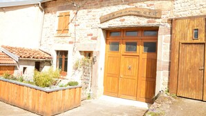 A stone building with a wooden door and a sign above it. - Small rustic cottage with terrace u. Hochgarten in outskirts (Tignécourt)