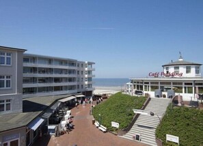 A coastal building with a cafe named 'Cafe Pudding' and a view of the beach.