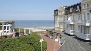Ett hotell vid kusten med flera balkonger och utsikt över stranden.