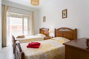 A hotel room with two beds, a wooden nightstand, a desk, and a window with curtains. - Isabel Dream IV, 4 Km from Sintra, train at 400m (Algueirão-Mem Martins)