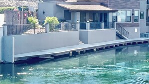 Une propriété située au bord de l’eau, dotée d’une piscine, d’un patio couvert et offrant une vue sur les collines.