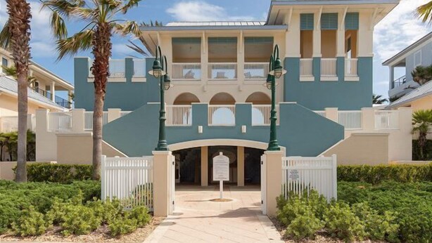 A multi-story hotel with a central courtyard, palm trees, and a gated entrance. - “Paradise Found” in this Direct Oceanfront Penthouse with Spectacular Sunrise Views. Unit 765 (Palm Coast)