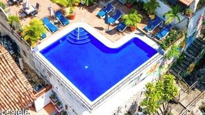 A multi-story building with a rooftop pool and outdoor seating areas.