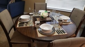 A dining table set for four with place settings, including plates, bowls, cutlery, and glasses. - CLOSE TO STRIP Very Private, GATED, Huge Open Floor Plan, WIFI, WASHER & DRYER (Las Vegas)
