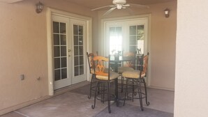 A covered patio area with a table and chairs, a ceiling fan, and a door with glass panels. - CLOSE TO STRIP Very Private, GATED, Huge Open Floor Plan, WIFI, WASHER & DRYER (Las Vegas)
