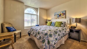 A bedroom with a large bed, a chair, a nightstand, and a window with blinds. - GOLF COURSE, 4 Bdrm Single Level w/Garage!!! (Meridian)