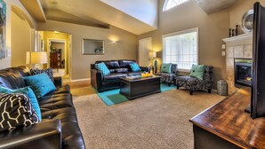 A spacious living room with a high ceiling, a fireplace, and a large window providing natural light. - GOLF COURSE, 4 Bdrm Single Level w/Garage!!! (Meridian)