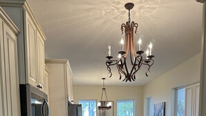 A spacious kitchen with granite countertops, a central island, and a dining area with a view of the outdoors. - Lakefront Southern Charm with private dock (Pinetta)