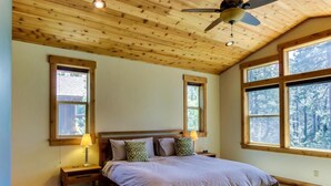 A bedroom with a wooden ceiling, a large bed, two nightstands, and three windows. - Tahoe Donner modern: Perfect for 3 families! 3 King/6 Twin. 4 BA, Cook's Kitchen (Truckee)